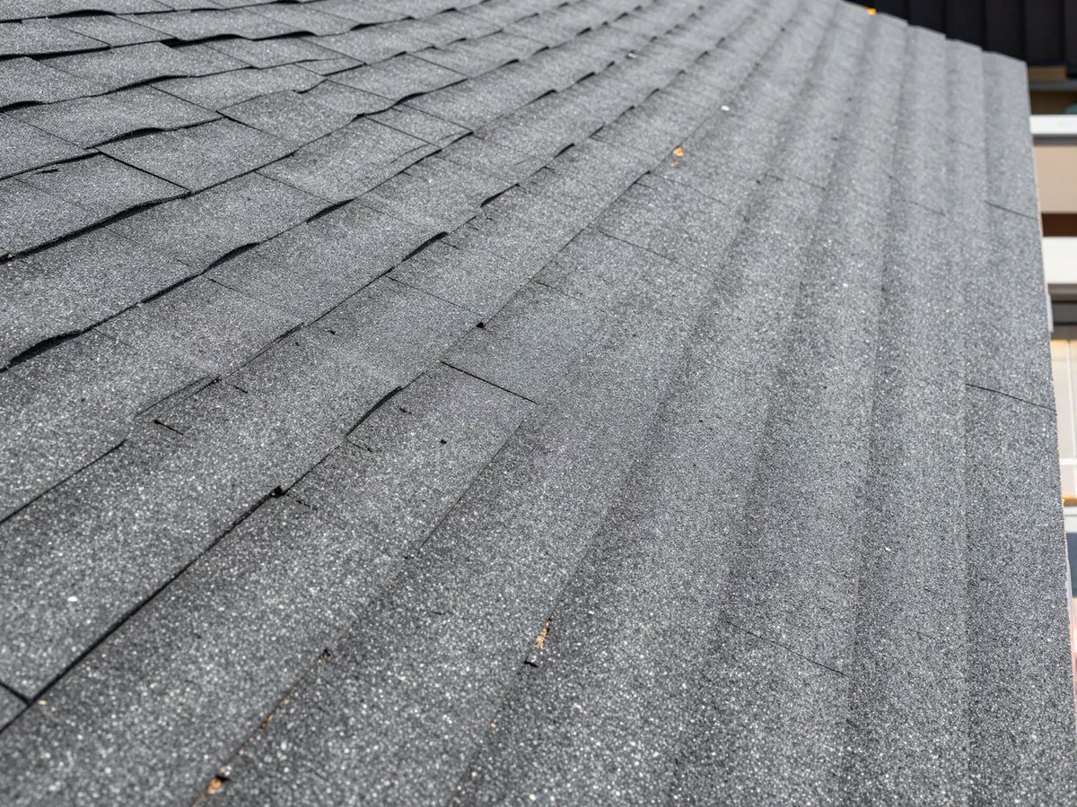 Close-up of overlapping asphalt shingles on a roof deck