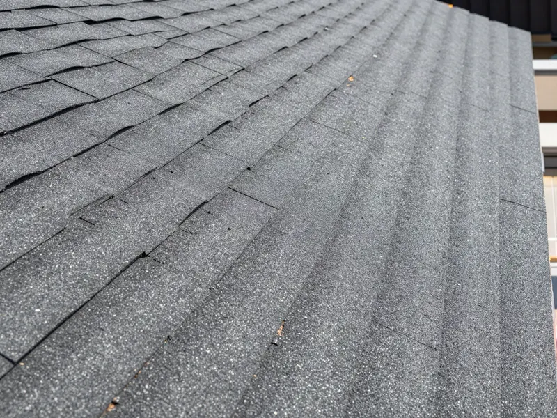 Close-up of overlapping asphalt shingles on a roof deck